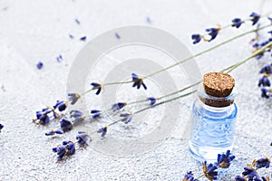 Spa and wellness setting with lavender flowers, sea salt, oil in a bottle, aroma candle on wooden white background