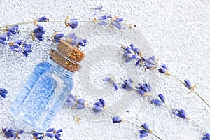 Spa and wellness setting with lavender flowers, sea salt, oil in a bottle, aroma candle on wooden white background