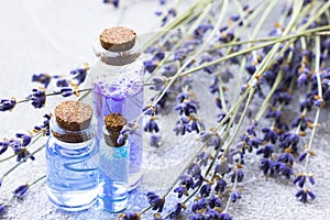 Spa and wellness setting with lavender flowers, sea salt, oil in a bottle, aroma candle on wooden white background