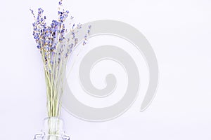 Spa and wellness setting with lavender flowers, sea salt, oil in a bottle, aroma candle on wooden white background