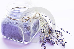 Spa and wellness setting with lavender flowers, sea salt, oil in a bottle, aroma candle on wooden white background