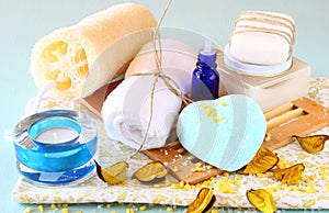 Spa and wellness setting with natural soap, candles and towel. aqua wooden background