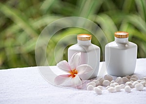 Spa and wellness setting with natural soap, stones and towel on the green background .