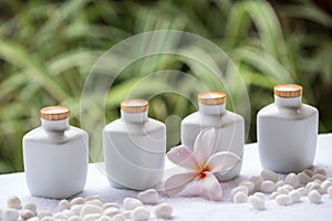 Spa and wellness setting with natural soap, stones and towel on the green background .