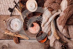 Spa and wellness setting with sea salt, oil essence, cones and candle, wooden decor on wooden background