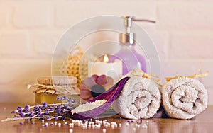Spa and wellness setting with white towels , sponge, candle, lav