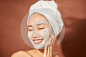 Spa Woman applying Facial clay Mask. Beauty Treatments