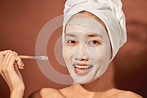 Spa Woman applying Facial clay Mask. Beauty Treatments