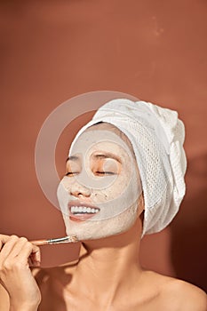 Spa Woman applying Facial clay Mask. Beauty Treatments