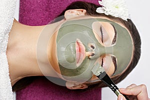 Spa Woman applying Facial clay Mask. Beauty Treatments. Close-up