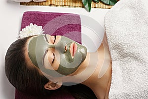 Spa Woman applying Facial clay Mask. Beauty Treatments. Close-up