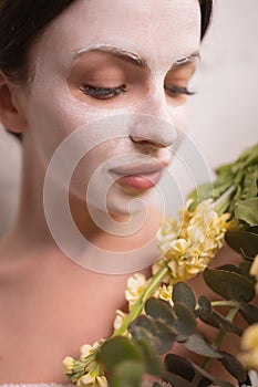 Spa Woman applying Facial clay Mask. Beauty Treatments. Close-up portrait of beautiful girl with a towel on her head