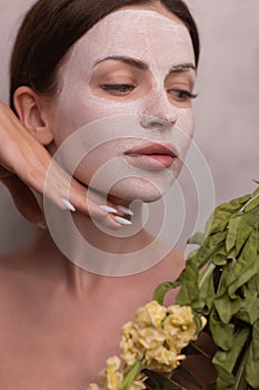Spa Woman applying Facial clay Mask. Beauty Treatments. Close-up portrait of beautiful girl with a towel on her head