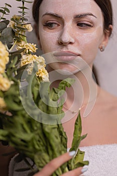Spa Woman applying Facial clay Mask. Beauty Treatments. Close-up portrait of beautiful girl with a towel on her head