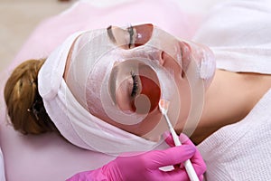 Spa Woman applying Facial cleansing Mask.