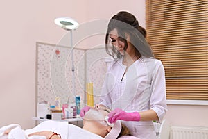 Spa Woman applying Facial cleansing Mask.