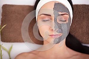 Spa Woman applying Facial cleansing Mask. Beauty Treatments