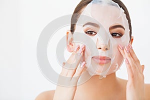 Spa Woman applying Facial cleansing Mask. Beauty Treatments