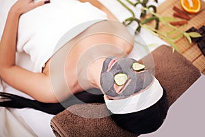 Spa Woman applying Facial cleansing Mask. Beauty Treatments. Clay mask