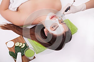 Spa Woman applying Facial cleansing Mask. Beauty Treatments. Clay mask