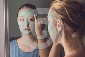 Spa Woman applying Facial green clay Mask. Beauty Treatments. Cl