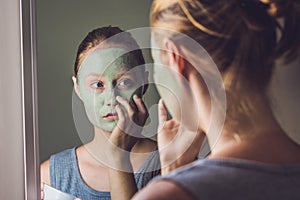 Spa Woman applying Facial green clay Mask. Beauty Treatments. Cl