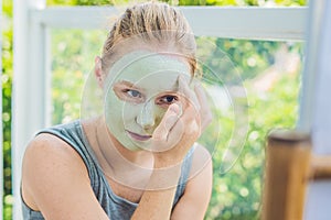 Spa Woman applying Facial green clay Mask. Beauty Treatments. Cl