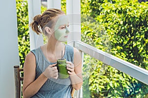 Spa Woman applying Facial green clay Mask. Beauty Treatments. Fresh green smoothie with banana and spinach with heart of sesame se