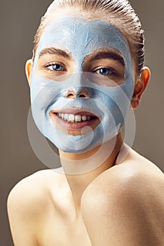 Spa Woman applying mask for face and smiling.