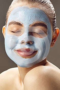 Spa Woman applying mask for face and smiling.