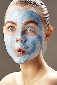 Spa Woman applying mask for face and is surprised