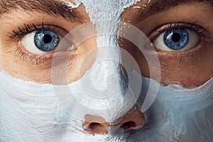 Spa Woman applying mask for face and is surprised