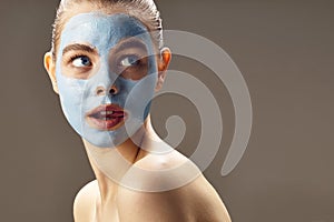 Spa Woman applying mask for face and is surprised