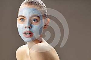 Spa Woman applying mask for face and is surprised