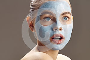 Spa Woman applying mask for face and is surprised