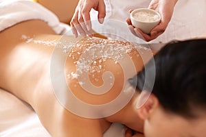 Spa Woman. Brunette Getting a Salt Scrub Beauty Treatment in the