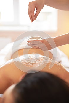 Spa Woman. Brunette Getting a Salt Scrub Beauty Treatment in the