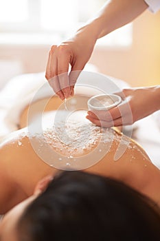 Spa Woman. Brunette Getting a Salt Scrub Beauty Treatment in the