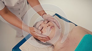 Spa woman facial Massage. Face Massage in beauty spa salon. Female enjoying relaxing face massage in cosmetology spa