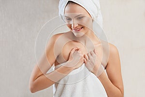 Spa Woman. Portrait of smiling young woman in towel in bathroom.