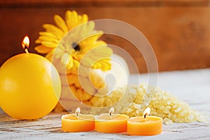 Spa yellow products setting. Sea salt ,towel and candles on dark wooden background