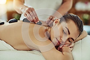 Spa, zen and woman getting a hot stone back massage for luxury, calm and natural self care. Beauty, body care and