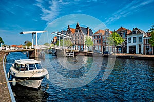 Spaarne river with boat and Gravestenenbrug bridge in Haarlem, N