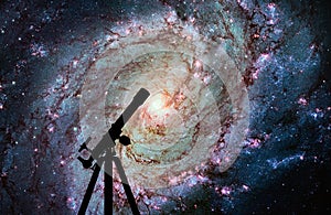 Space background with silhouette of telescope. Messier 83 photo