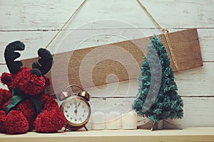 Space copy on wooden hanging and red reindeer doll with christmas tree and simulation candle light