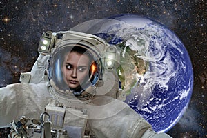 Space exploration. Astronaut woman in outer space. Planet earth from space on a dark background. Elements of this image were