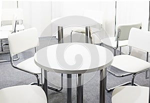 space, meeting room in light colors. Tables and chairs are white. Nobody
