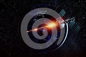 Space military satellite, a weapon in space shoots a laser against the background of the earth. Attack, technology, space war.