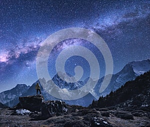 Space with Milky Way, man on the stone and mountains