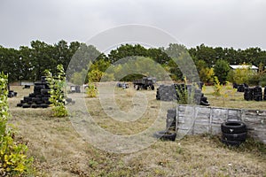 Space for playing paintball with the paint marks after fights. Abandoned paintball playground with barricades made of old tires